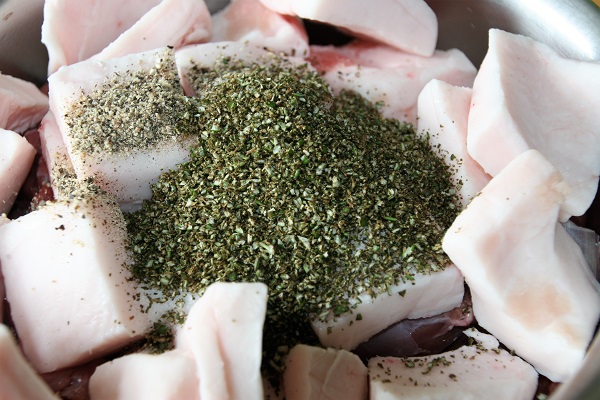 Die Gewürze für die Rehbratwürste vor dem Durchdrehen durch den Fleischwolf zum Rehfleisch geben
