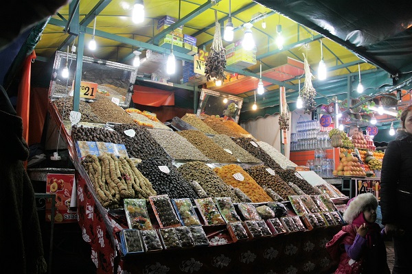 Abbildung zeigt eine Stand mit getrockneten Früchten auf dem Markt in Marrakesch bei Nacht