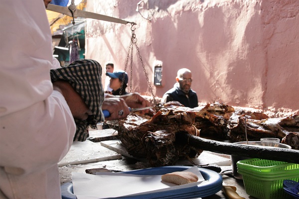 Abbildung gebackenes Schaf auf Holzspieß wird in Marrakesch auf dem Markt angeboten