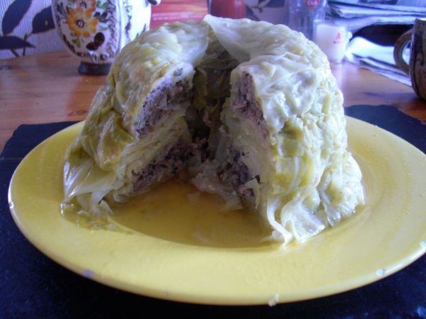 Foto Gugelhupfkuchen aus Weißkohlblätter und Bratwurstbrät angeschnitten auf einem gelben Teller