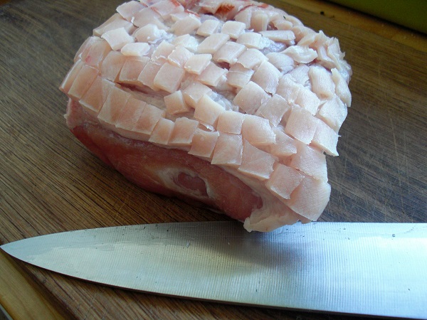 Schweineschwarte mit einem Messer einschneiden