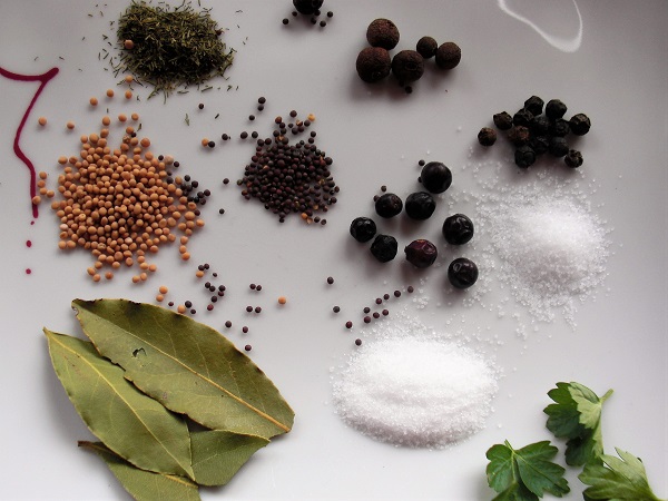 Foto Gewürze Lorbeerblatt Senfkörner Wacholderbeeren Salz Zucker Pfeffer Dill Petersilie auf weißem Teller