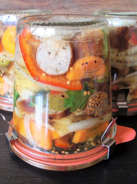Foto Einweckglas mit Gemüse und Bratwurstscheiben auf dem Kopf gestellt