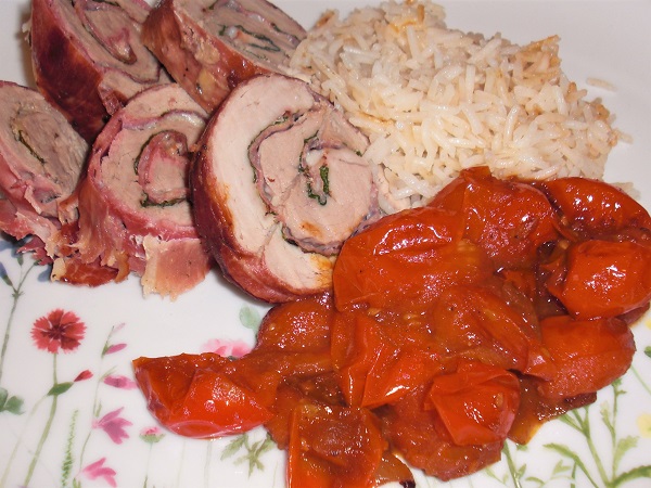 Foto Schweinerouladen mit Schinken-Käsefüllung und Kirschtomaten und Reis auf Teller mit Blumenwiesemuster