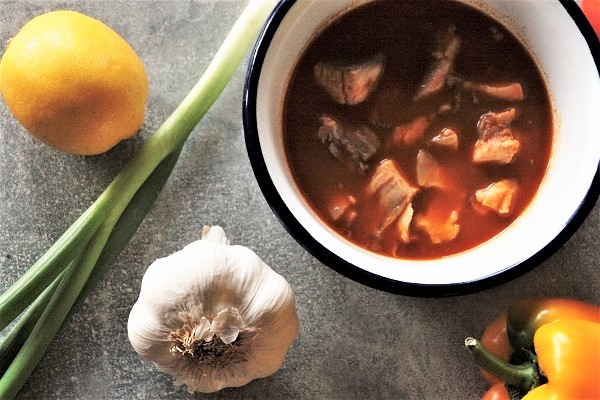 Foto rote Fischsuppe mit Karpfen in einer weiß emaillierten Schüsselchen