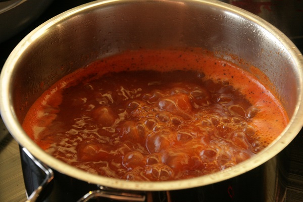 Foto rote Fischsuppe sprudelt in einem Kochttopf