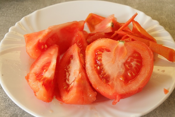 Foto enthäutete Tomate auf einem weißen Porzellanteller