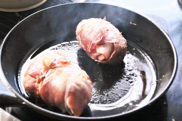 Foto Schweinerouladen mit Bratwurstbrät in einer Pfanne mit heißem Fett