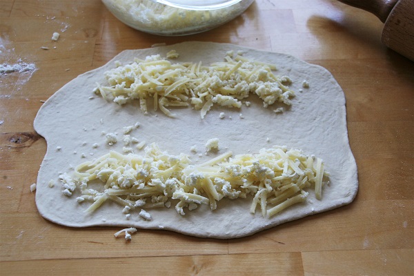 Foto ausgerollter Hefeteig mit Käse belegt