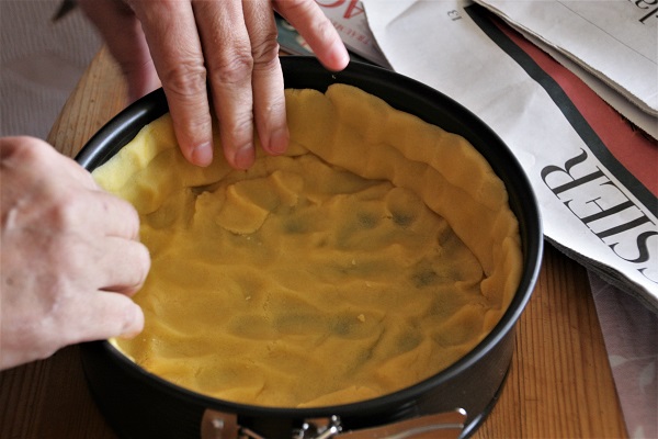 Kuchenform wird mit Mürbteig ausgelegt