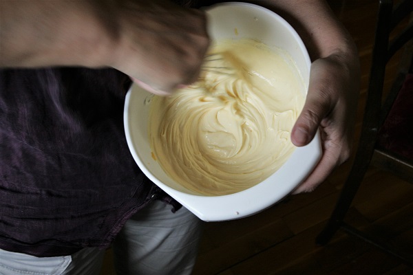 Quark und weitere Zutaten für den Käsekuchen werden verrührt