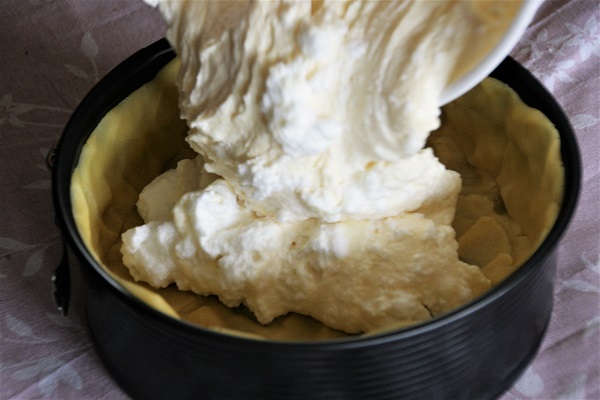 Quarkmasse wird in eine Kuchenform gegossen